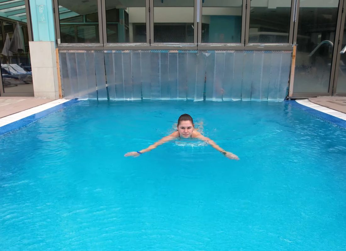 devojka pliva u bazenu u banji